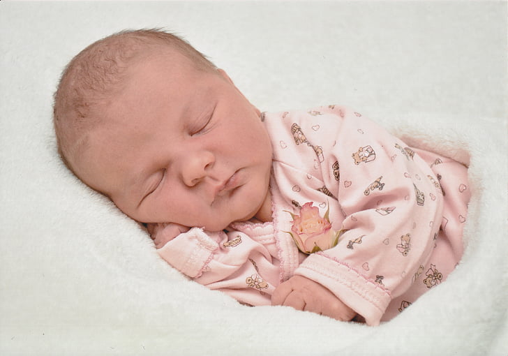 closeup photography of baby wearing pink sleeper