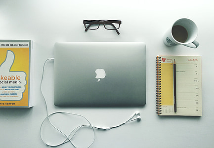 flat lay photography of silver MacBook beside spiral book and cup of coffee