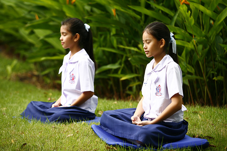 two girls in uniforms meditating