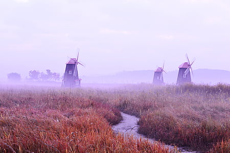 three wind mills on brown and green grass field