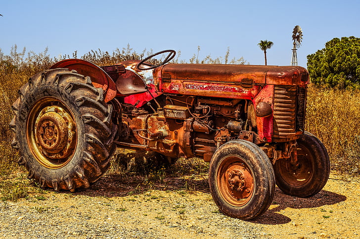 red and brown tractor near withered plant