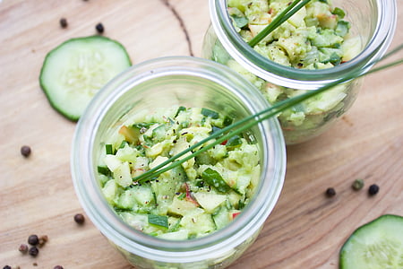 diced cucumbers in clear glass jar on brown wooden surface