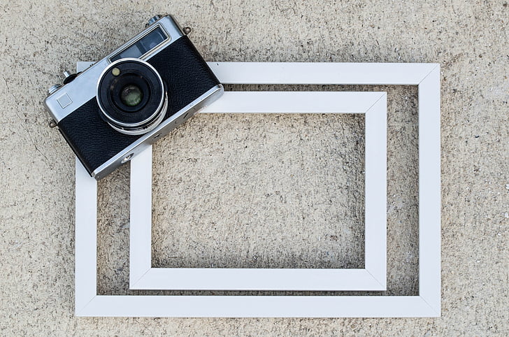 gray and black SLR camera on white wooden surface
