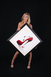 woman holding photo of red stiletto shoe