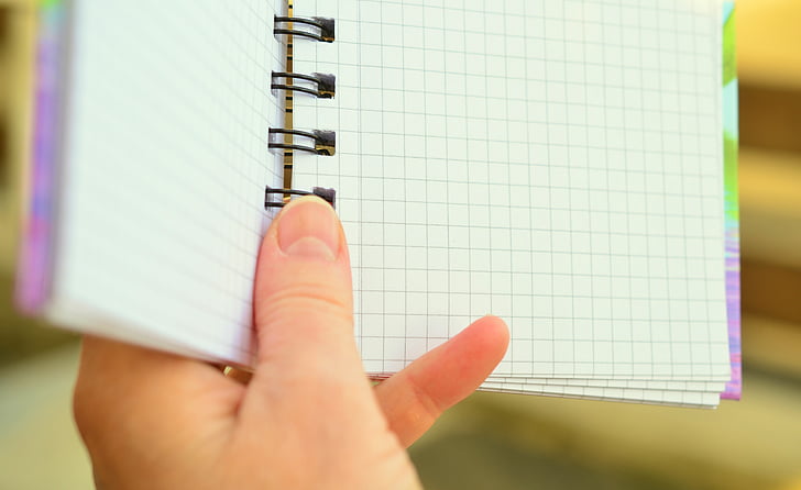 person holding spring notebook