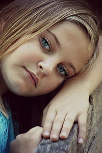 closeup photo of girl leaning on brown wooden surface