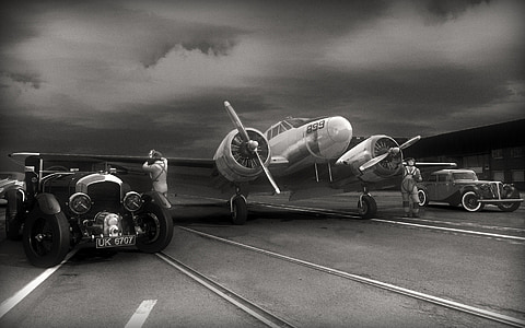 grayscale photo of airplane and cars