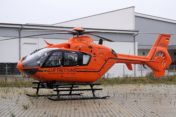 orange helicopter on ground near building