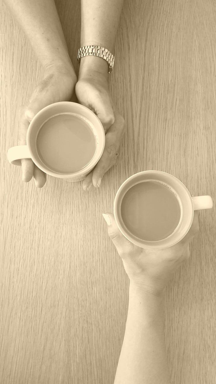 photographed of two person holding mugs