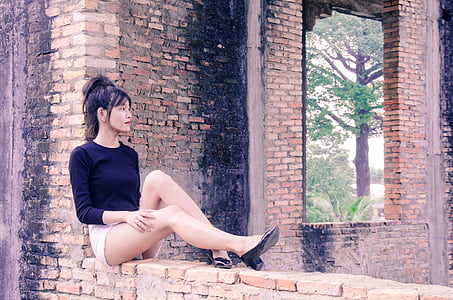 woman sitting on brick