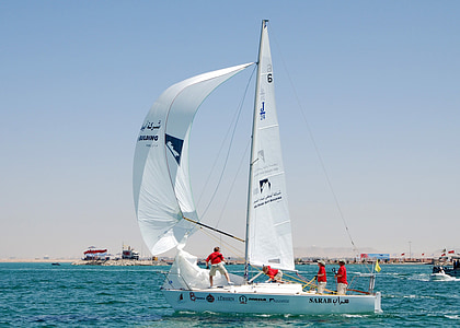 four people riding sailboat on body of water