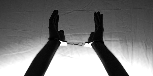 person's hand with handcuffs
