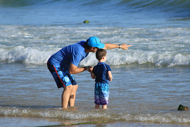 man and boy standing on shore