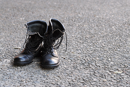 black leather combat boots on gray surface