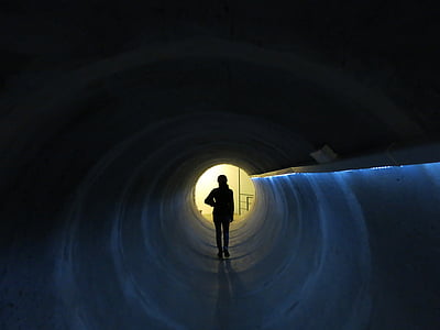 person standing inside tunnel