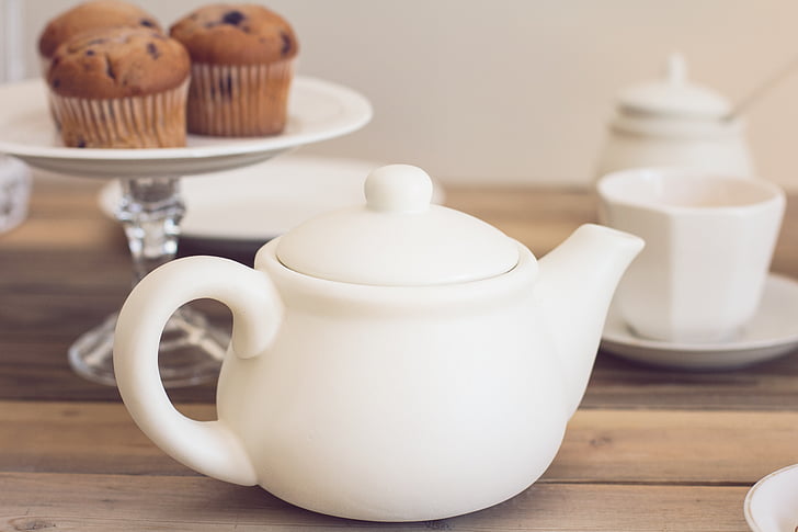 white ceramic teapot near footed cupcake stand