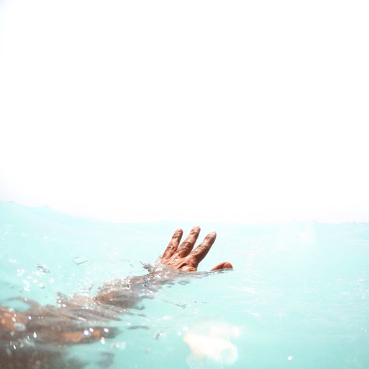 left human hand on body of water