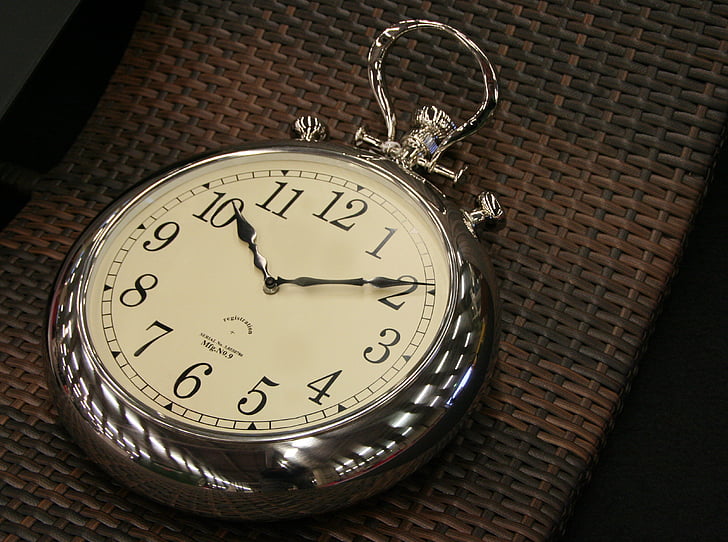 round silver-colored pocket watch time check at 10:10