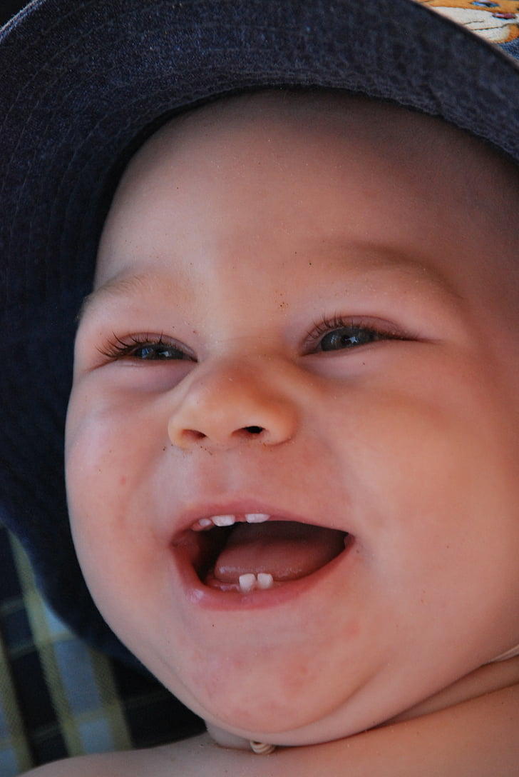 smiling baby wearing gray hat