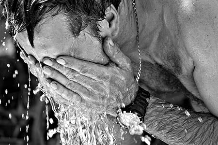 grayscale photography of man washing face