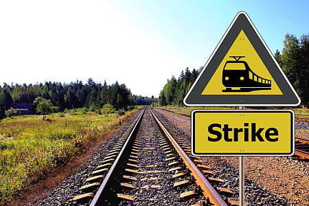 yellow-and-black train strike signage at daytime with no train