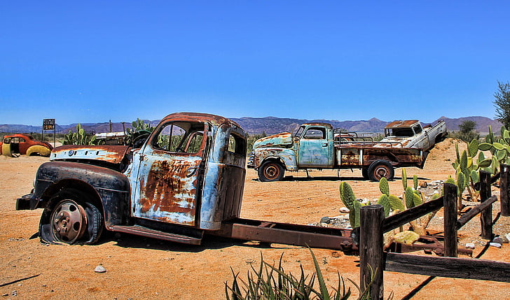 rusted vehicles on desert