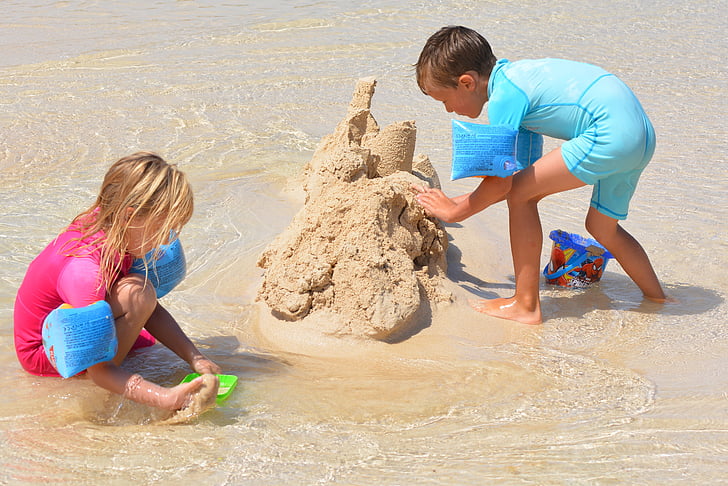 boy and girl build sand castle