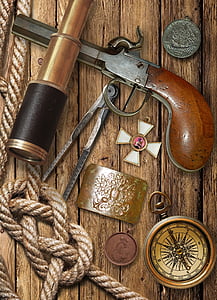 brown flintlock pistol and compass