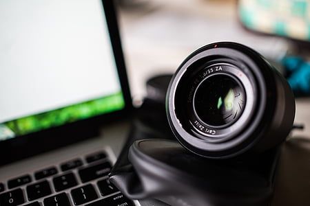 black camera lens near gray laptop computer in closeup photography