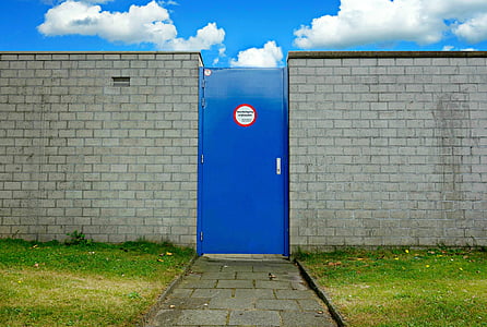 closed blue door near gray brick walls
