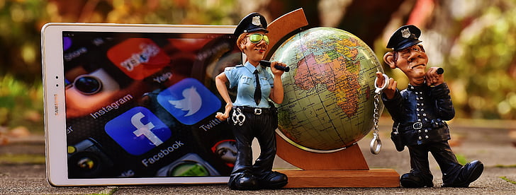 police man figurine beside smartphone