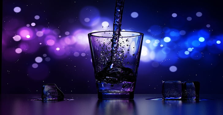 bokeh time lapse photography of liquid poured on shot glass