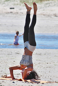 woman standing upside down on yoga mat