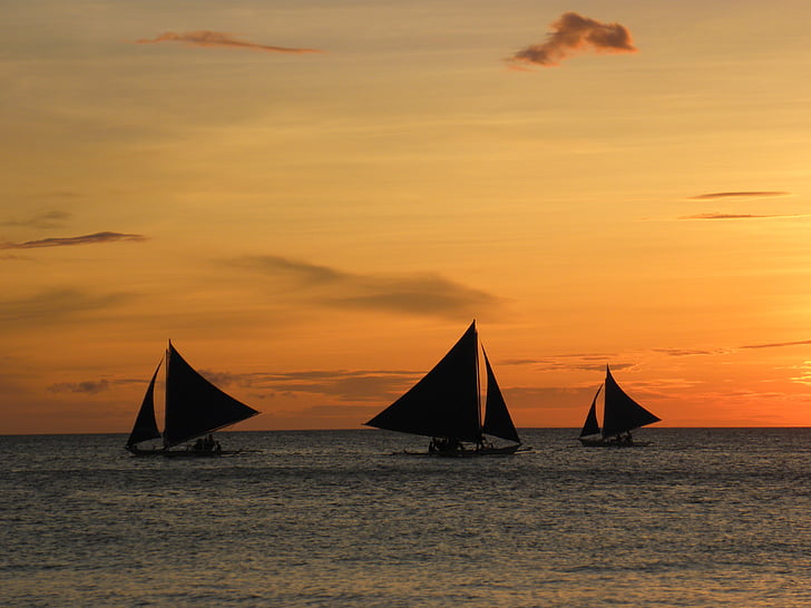 silhoutte of sailboats during sunset