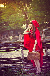 red riding hood near wooden fence photograph