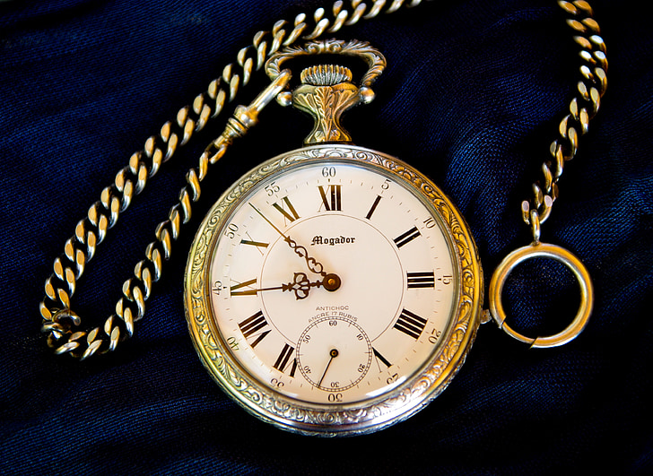 gold-colored roman pocket watch