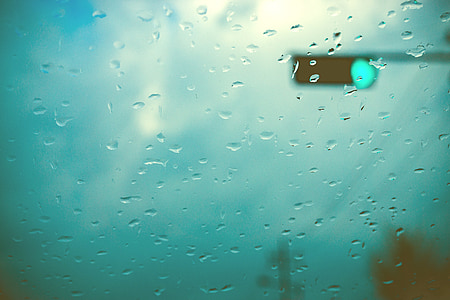 water drops on window overlooking traffic light turning green