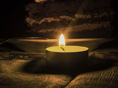 lighted tealight on brown fabric surface