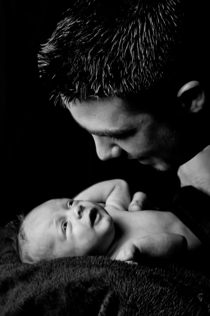 grayscale photo of man facing baby photo