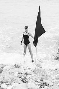 woman holding flag standing on body of water