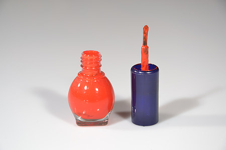 orange nail polish bottle on white surface