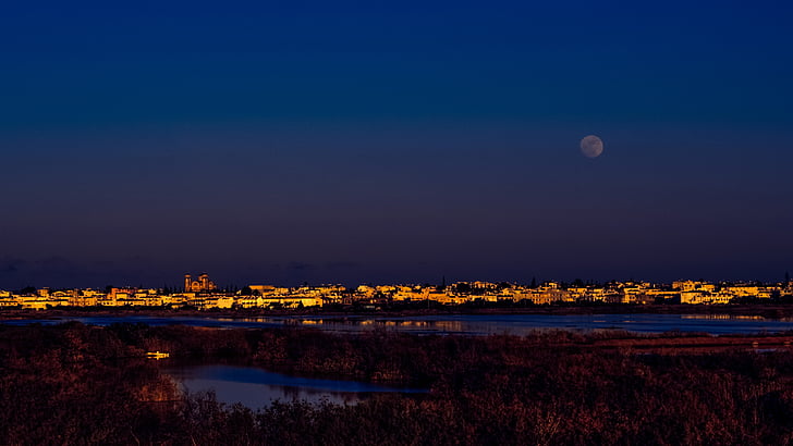 lighted city with full moon