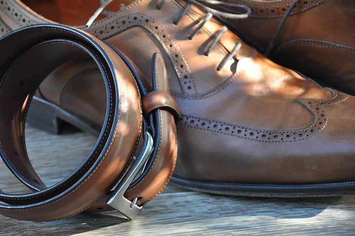 brown leather belt beside derby shoes