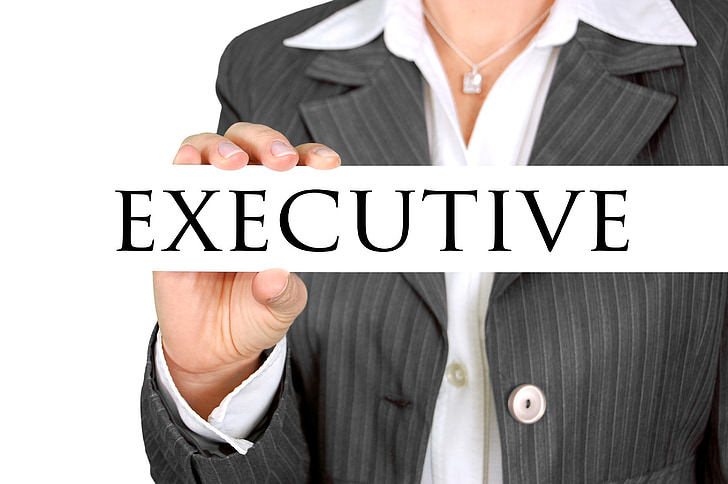 person in black button-up top holding executive signage