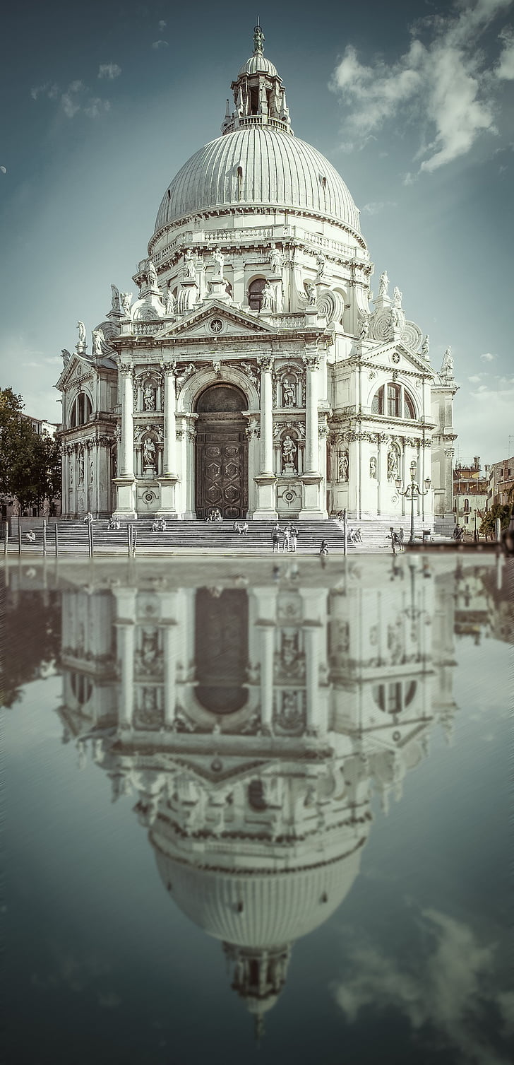 white concrete dome structure with reflection on water