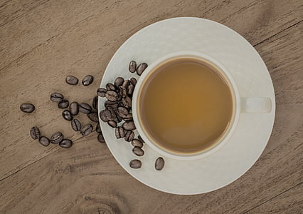 flat lay photography of cup of coffee with coffee beans