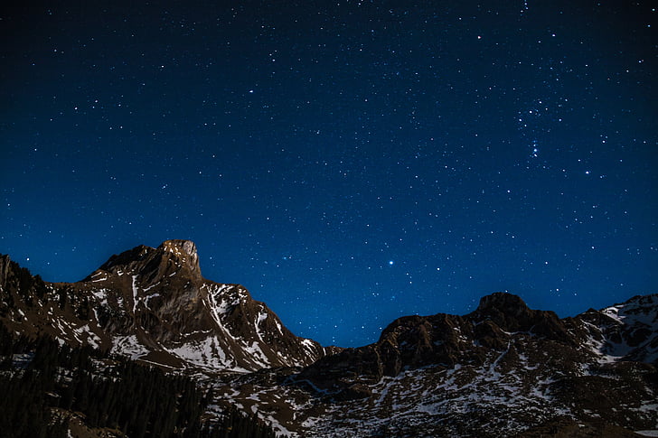 snow capped mountains under the starry skies