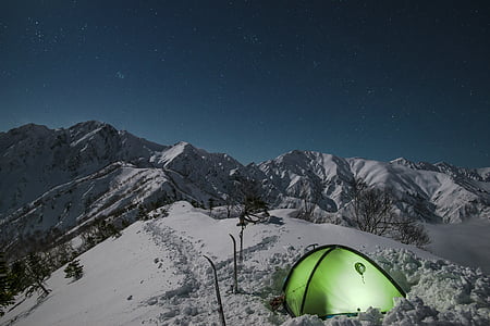 green camping tent on top of snow mountain