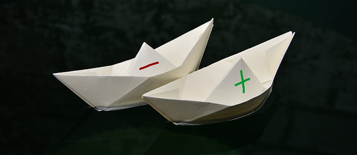 two white paper boats on body of water