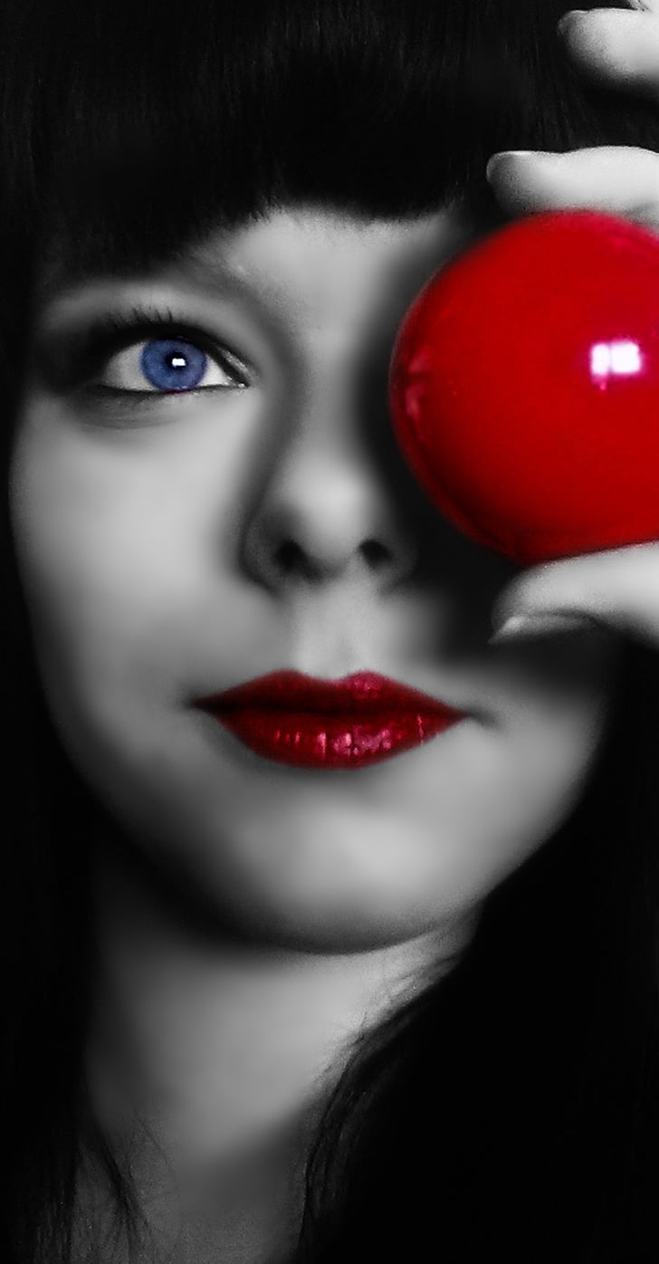 woman holding red ball in color selective photography